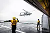 Et helikopter er i ferd med å lande på et skip.