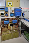 Veggen i labe-en er full av elektronikk, konvertere og transformatorer. Gamle batterier under, de nyere til høyre.