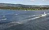 Det nye helikopteret NH90 står nærmest stille i luften bak fregatten. Helt til høyre i bakgrunnen: Holmenkollbakken og Oslo.