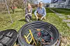 Seniorforsker Guro K. Svendsen og forskningsleder Volker Oye i bakhagen til Norsar på Kjeller, hvor er strukket fiberkabler mellom slike brønner som den på bildet. Kablene brukes til å registrere rystelser i bakken.