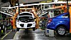 En Chevy Bolt (hvit) på produksjonslinja sammen med en bensindrevet Chevy Sonic sedan.