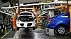 En Chevy Bolt (hvit) på produksjonslinja sammen med en bensindrevet Chevy Sonic sedan.