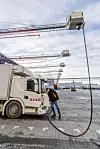 Solenergien som produseres hos Asko Vestby, går til å forsyne 58 ladepunkter for tunge kjøretøy og til å holde 20 minusgrader på frys. Selskapet har selv utviklet ladesystemet der en ladekabel blir vinsjet ned før den kobles til lastebilen. Det er også sprinkleranlegg på «jernarmen». Foto: Arash A. Nejad