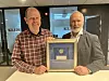 Roar Telle i Veiteknisk Institutt og styreleder for Kontrollordrningen for Asfaltgjenvinning, Knut Li, viser fram den første femkroningen som ble innbetalt til ordningen av Statoli i 2001.