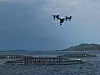 Drone inspiserer oppdrettsanlegg fra lufta. I Artifex-prosjektet er det meningen at den skal sendes opp fra og landes på en ubemannet overflatefarkost (USV). Foto: Eirik Svendsen/SINTEF OCEAN