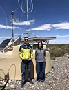 Domenik Ehlert og Foteini Oikonomou foran en av de 1600 overflatedetektorene som hører til Pierre Auger Ultra-high Energy Cosmic Ray Observatory i Malargue i Argentina. Foto: Privat