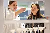 To kvinner arbeider sammen ved et laboratorium med prøveflasker og utstyr i forgrunnen.
