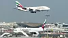 Et A380-800 går inn for landing i Dubai, der det står et B777-300ER parkert.
