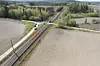 Dronefoto som viser kjøreretningen til traktor (blå pil) og persontog (rød pil). Etter sammenstøtet stoppet togsettet 281 meter forbi planovergangen. Foto: Havarikommisjonen