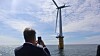 Olje- og energiminster Terje Aasland foreviger en flytende vindturbin utenfor Karmøy i mai, under et besøk på Marine Energy Test Centre, et testsenter for havvind.