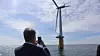 Olje- og energiminster Terje Aasland foreviger en flytende vindturbin utenfor Karmøy i mai, under et besøk på Marine Energy Test Centre, et testsenter for havvind.