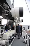 En delegasjon fra Kongsberg Maritime under den automatiske fortøyningsroboten fra MacGregor i Kristiansand. Yara Birkeland har en forut og en akter på styrbord side.