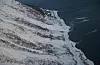 Et snøskred er løst ut med sprengladning fra helikopter ved Singla. Skredet har passert fylkesveien og havnet i sjøen. Foto: Troms fylkeskommune