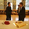 Administrerende direktør Nils Morten Huseby (t.h.) serverer atommerket kake til daglig leder Nils Bøhmer i Bellona for å feire at Venstre (representert med Abid Q. Raja i bakgrunnen) økte bevilgningene til Ifes atomopprydding med 20 millioner kroner i budsjettforliket. Foto: Øyvind Lie