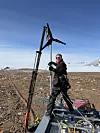 Ravn Winsvold Rydtun installerer en av de tre vindmøllene som etter planen skal forsyne målestastasjonen med strøm i mørketiden. Foto: privat/Norsar
