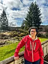 Den planlagte 275 meter høye vindturbinen kommer i bakgrunnen mellom trærne Bente Halsvik ser fra verandaen hjemme på småbruket i Halsvik. Hun frykter helseskader. Foto: Privat