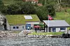 NYTT FORSAMLINGSHUS: Måren kraftverk sett fra sjøen. Foran står det nye forsamlingshuset som grenda har fått av BKK.
