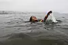 Nina Gomes henter en plastpose fra havet, nær Copacabana-stranden i Rio de Janeiro. Den åtte år gamle brasilianske miljøaktivisten har brukt årevis på å samle søppel i vannet på Copacabana-stranden og lære andre barn metoder for bevaring. Bildet er fra 2024. Foto: Bruna Prado/AP Photo/NTB